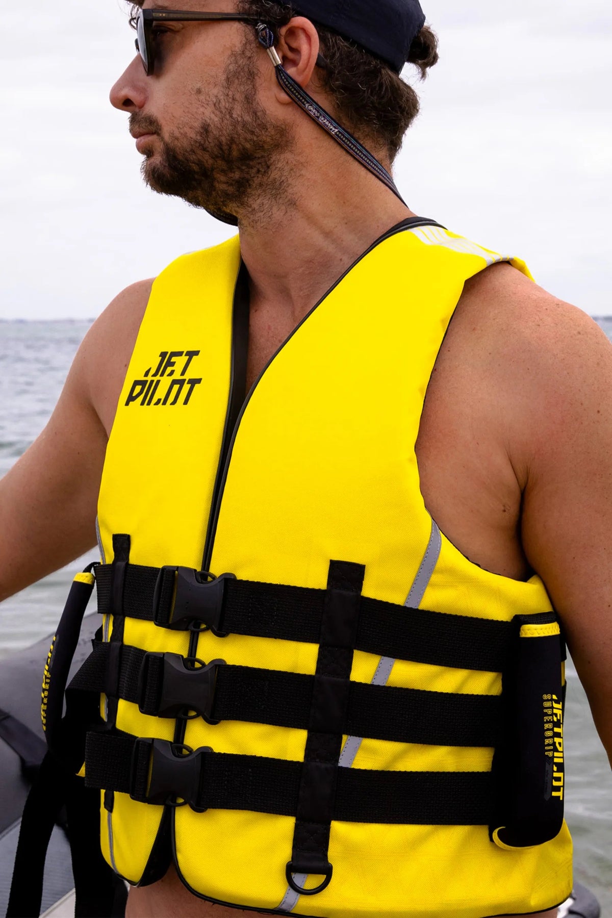 Model in the Black/Yellow Titan Nylon life jacket on the water, with the three front buckles done up
